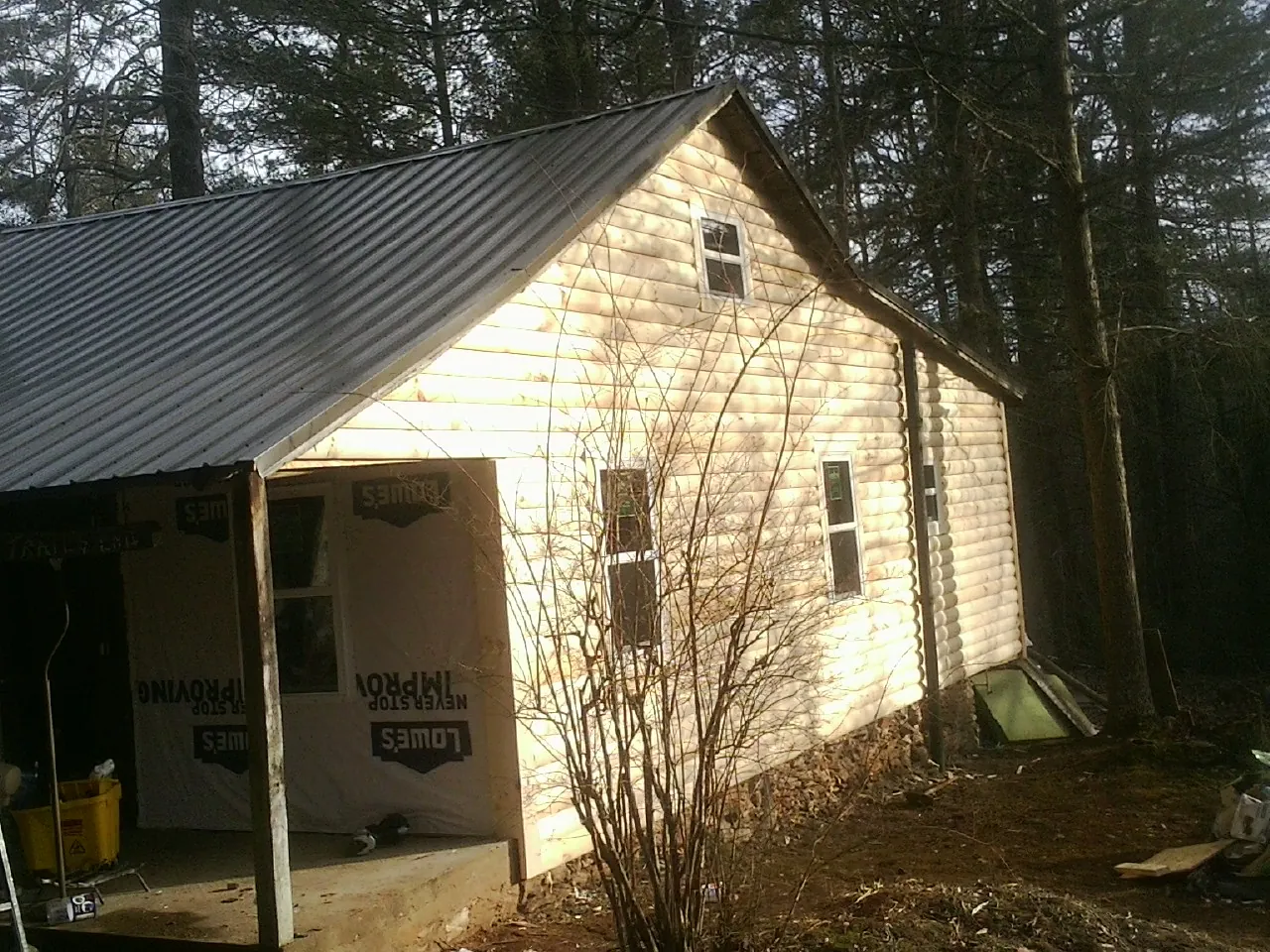 Log siding gable end under a dark metal roof edge in Scottsville