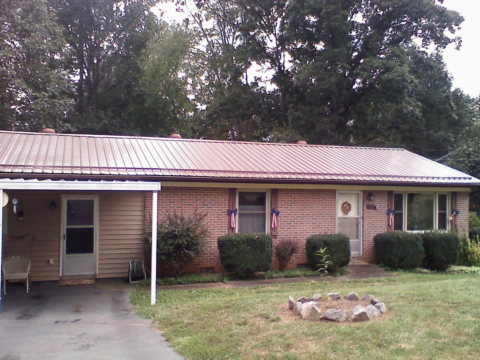 Bronze metal roof and carport on a brick ranch home — Roof Repair work by our crew in Scottsville